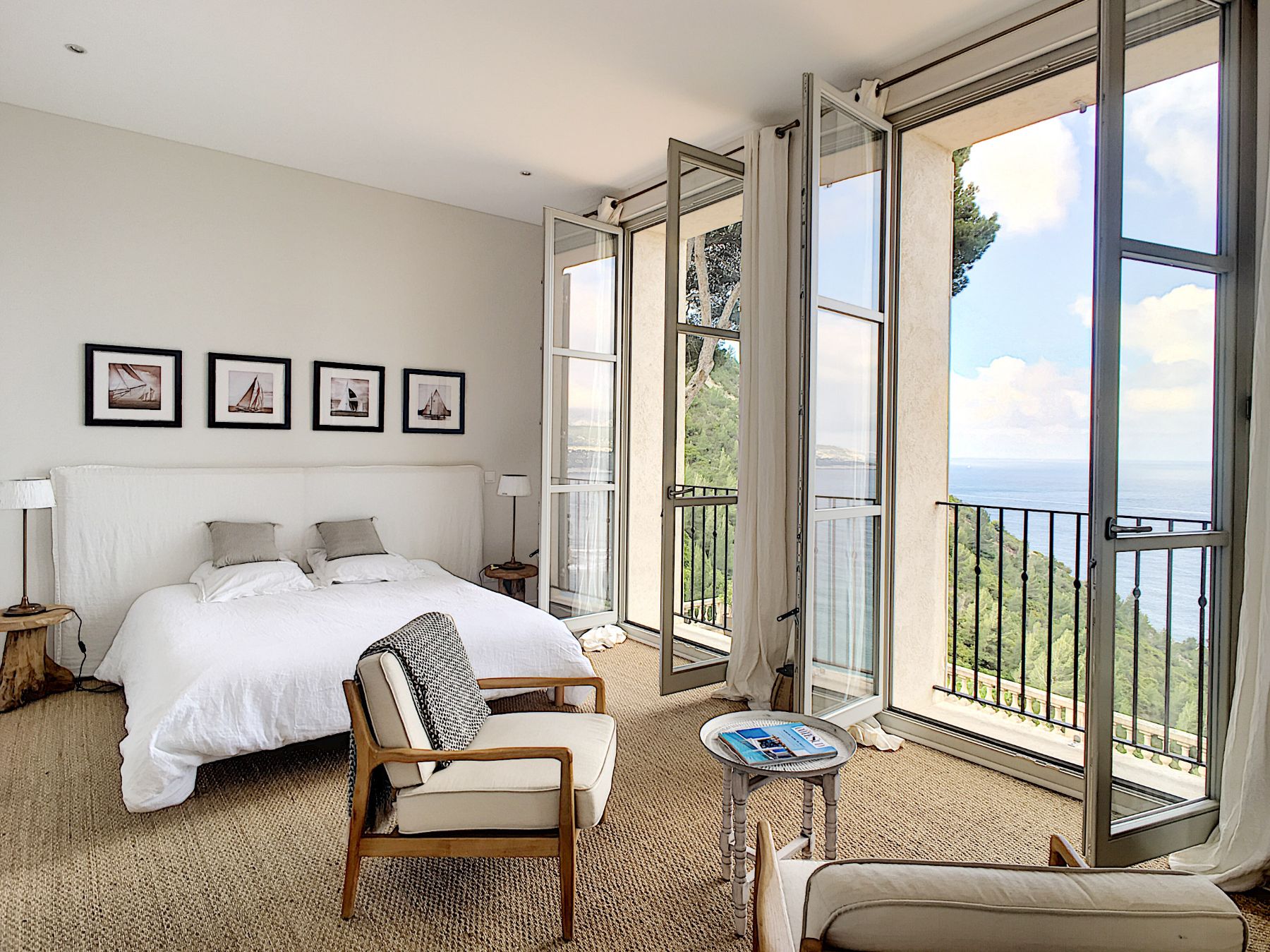 White double bedroom with chair and double door sea view at Villa Florie in Côte d'Azur