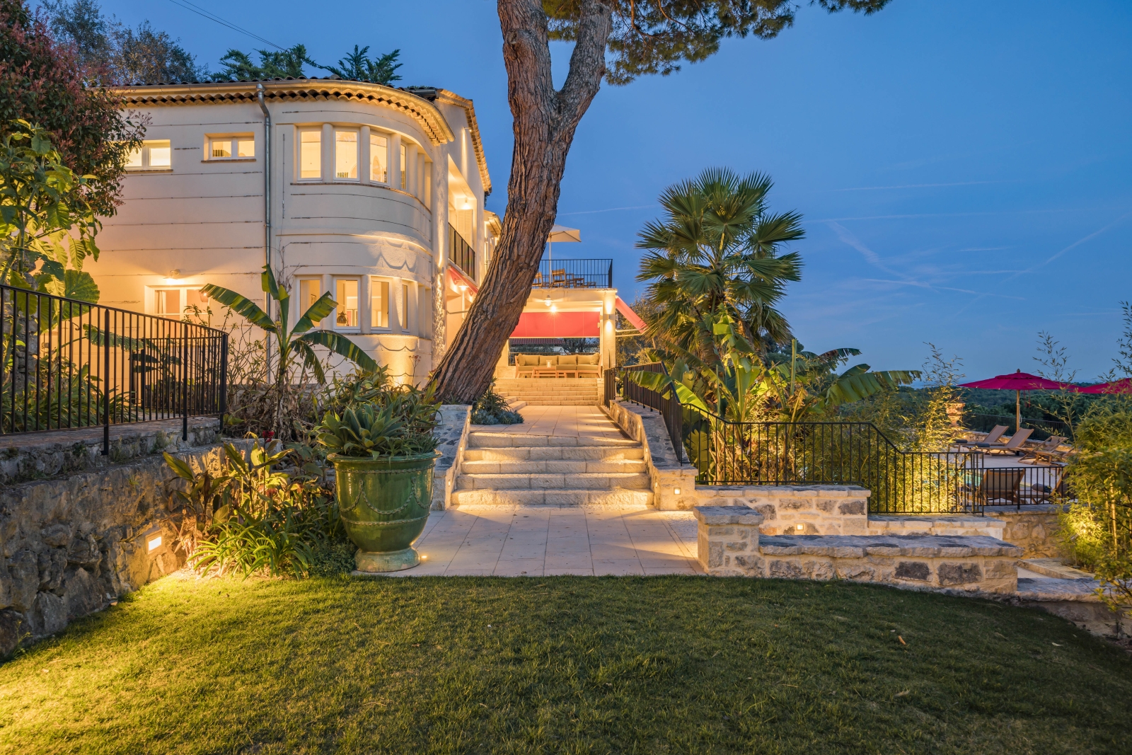 Exterior night shot of Villa Malvan, with a stairs leading up to the illuminated outdoor sitting area