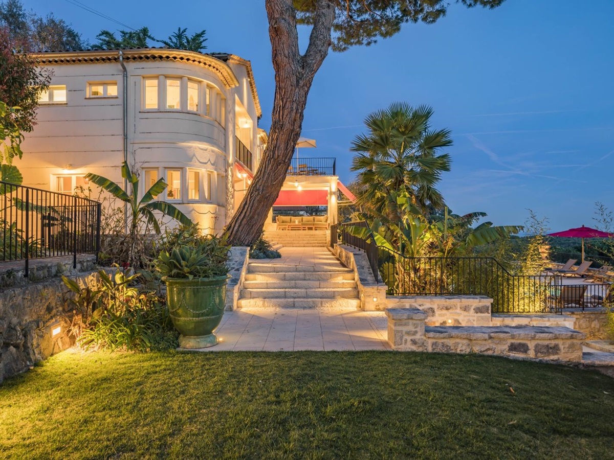 Exterior night shot of Villa Malvan, with a stairs leading up to the illuminated outdoor sitting area