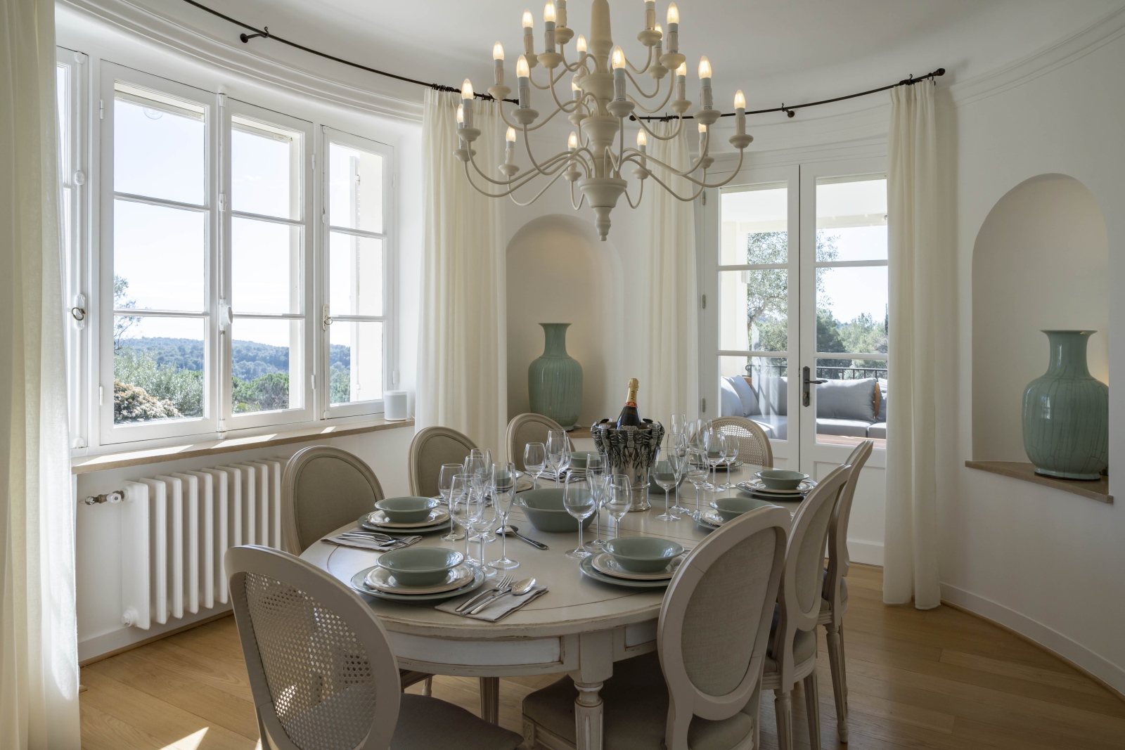 Elegant indoor dining area withlarge decorative vases and beautiful views over the French coutryside at Villa Malvan, luxury villa in the Cote d'Azur