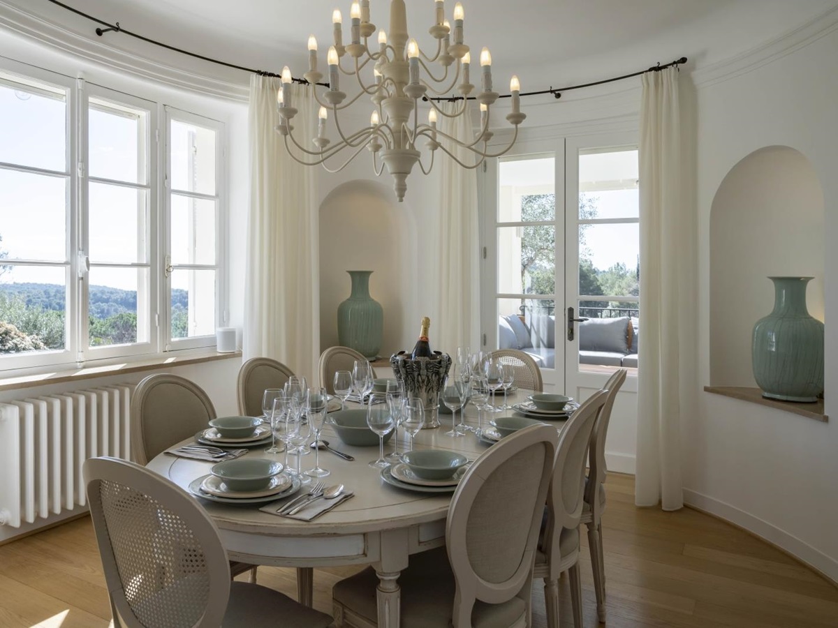 Elegant indoor dining area withlarge decorative vases and beautiful views over the French coutryside at Villa Malvan, luxury villa in the Cote d'Azur