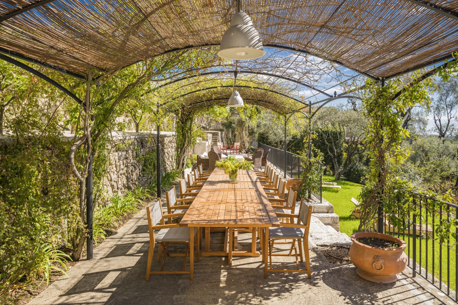 Extensive outdoor dining table on the terrace of Villa Malvan, overlooking the lush gardens