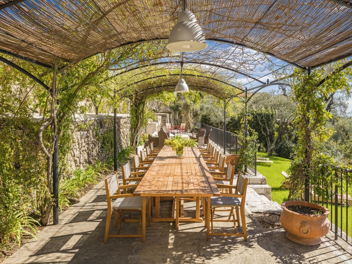 Extensive outdoor dining table on the terrace of Villa Malvan, overlooking the lush gardens