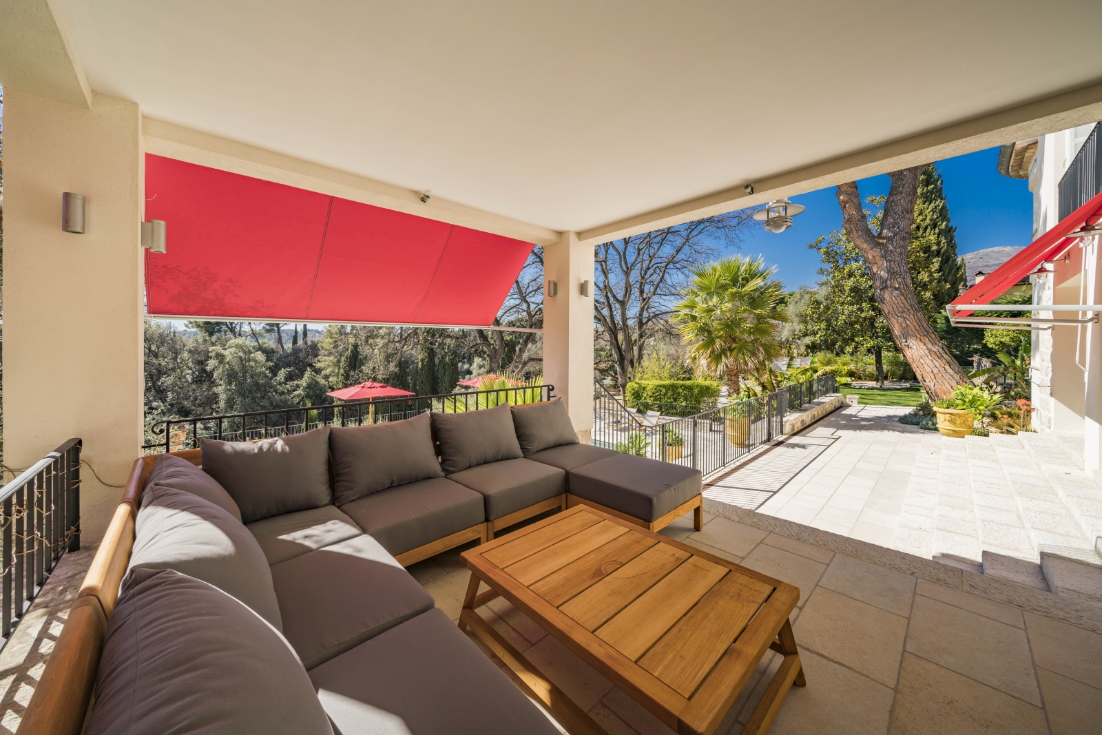 Shaded outdoor lounging area overlooking the pool and gardens of Villa Malvan, luxury villa in the Cote d'Azur region of France