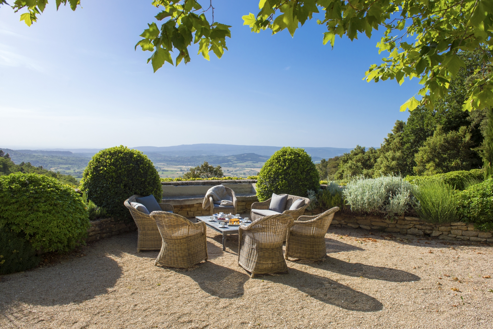 Lounge area with comfy chairs, coffee table and countryside view at Bastide de la Paix in Provence, France