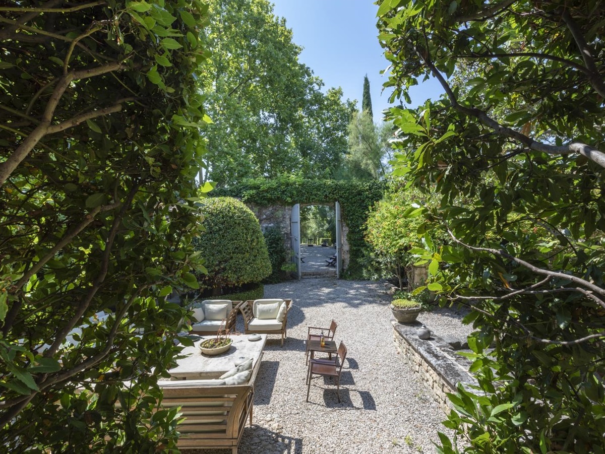 Gardens with hedges, trees and comfy seating area at Bastide Luberon in Provence, France