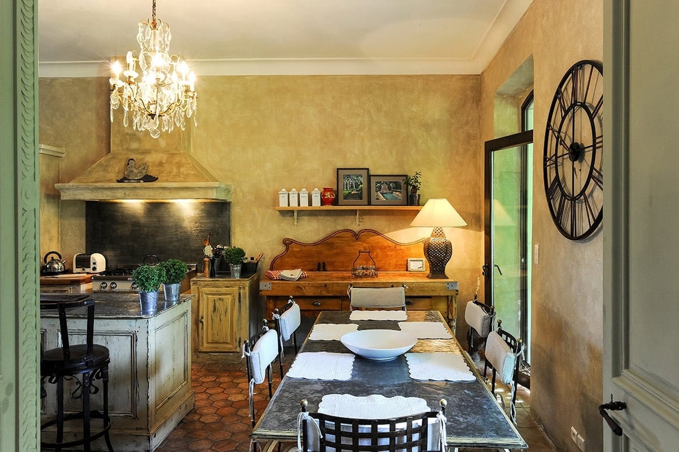 Kitchen with dining table and large oven at Bastide Sur La Sorgue in Provence