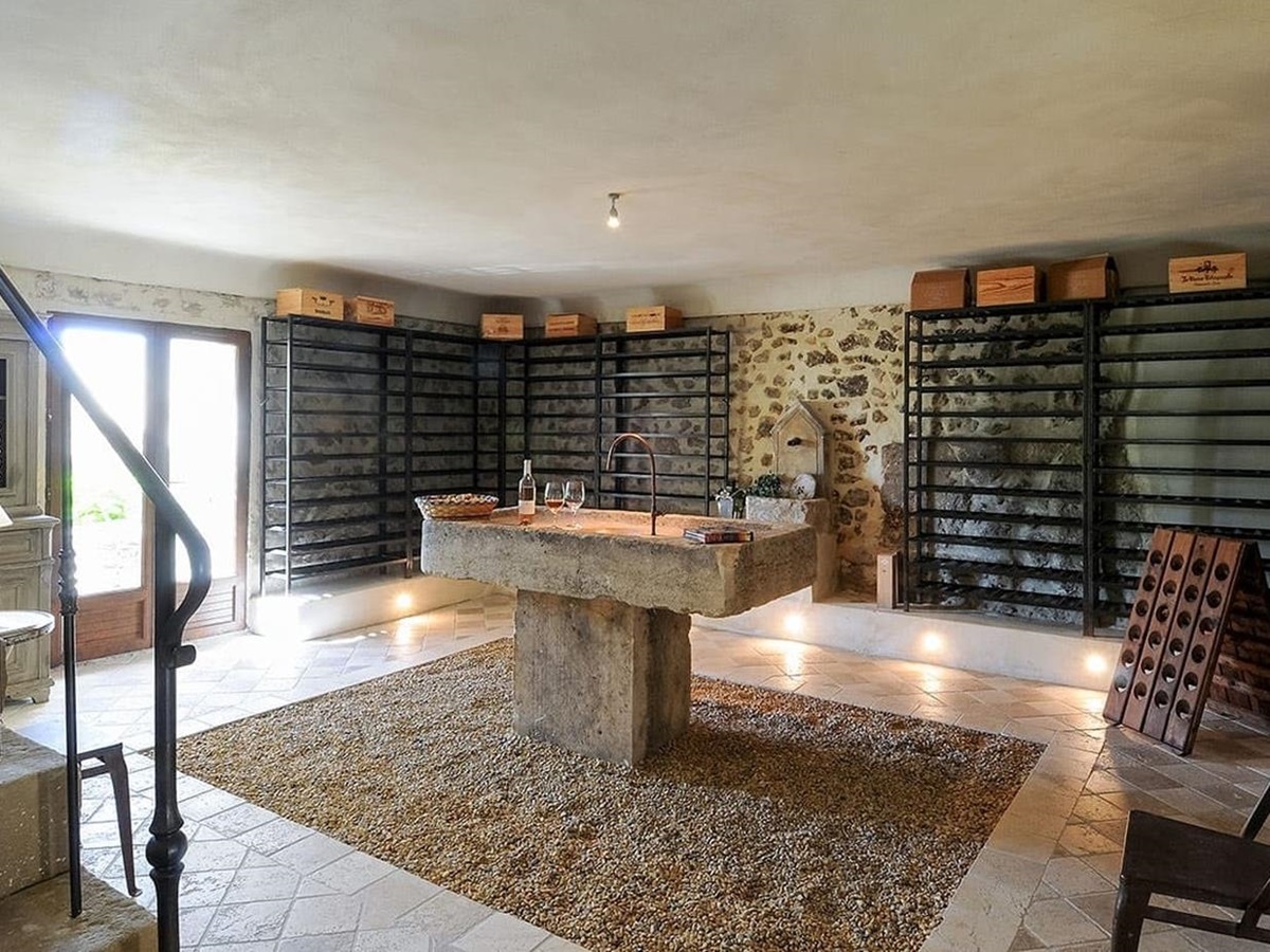 Stone wine cellar with tasting table at Bastide Sur La Sorgue in Provence