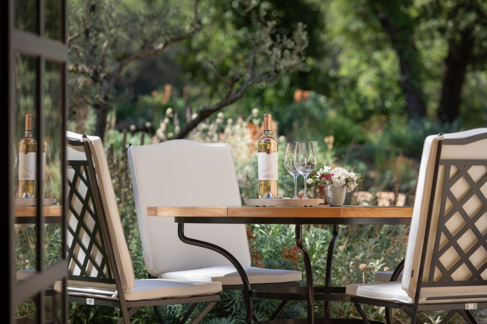Outdoor dining table with flowers, wine and wine glasses at Chateau Margui in Provence, France
