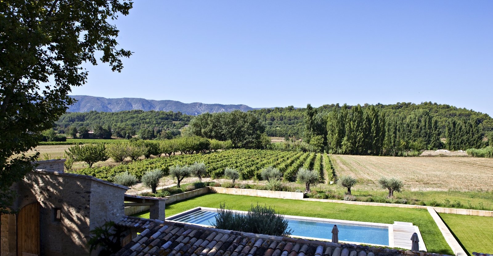View of garden, pool, surrounding countryside and hills at Domaine des Baumettes in Provence, France