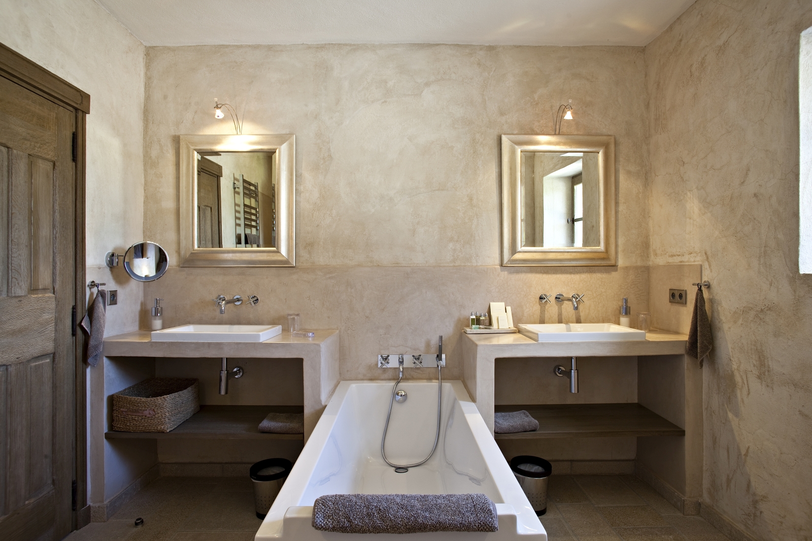 Bathroom with two sinks, two mirrors, bath and lights at Domaine des Baumettes in Provence, France