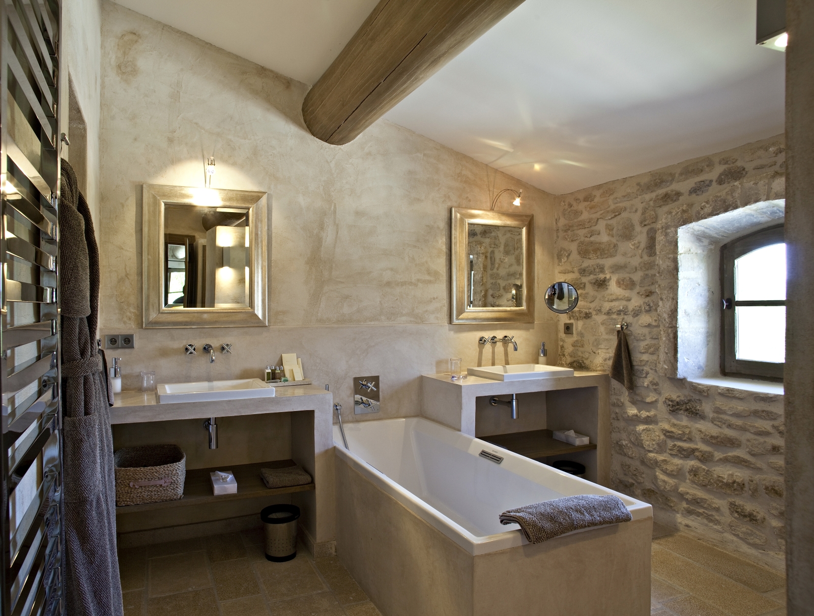 Bathroom with two sinks, two mirrors, bath, lights, towel rail and window at Domaine des Baumettes in Provence, France