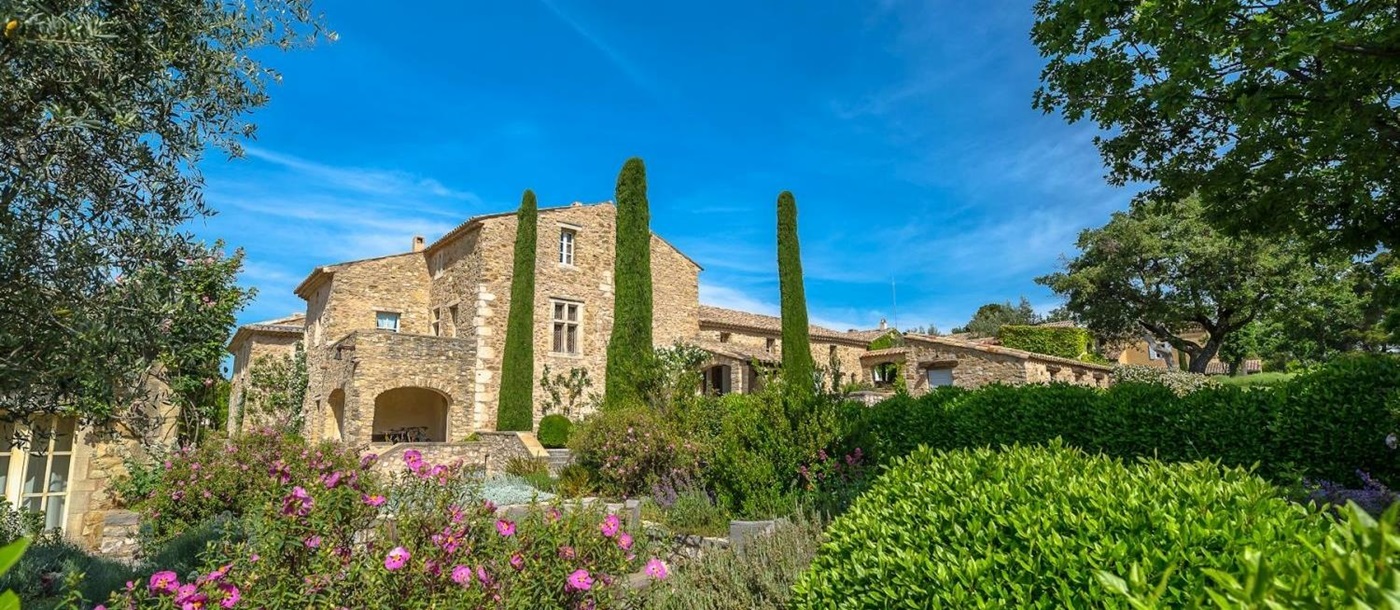 Façade and gardens with plants, flowers and trees at Domaine des Coteaux in Provence, France