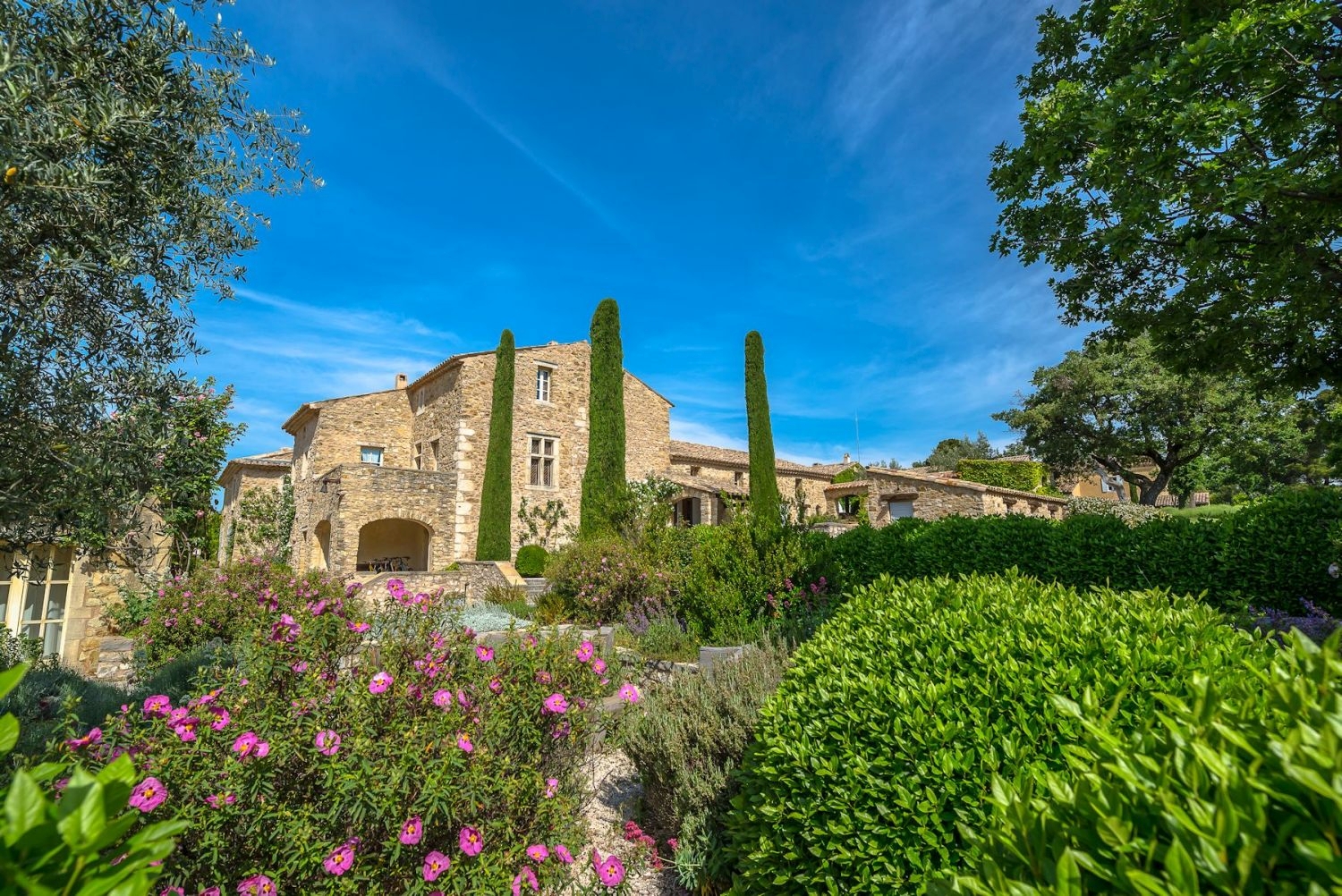 Façade and gardens with plants, flowers and trees at Domaine des Coteaux in Provence, France