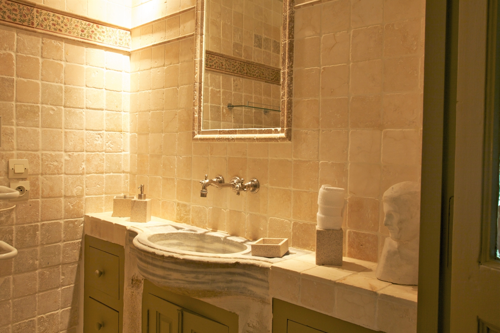 Bathroom with stone sink unit and mirror at Le Pont Romain in Provence, France