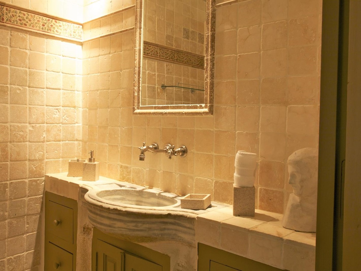 Bathroom with stone sink unit and mirror at Le Pont Romain in Provence, France