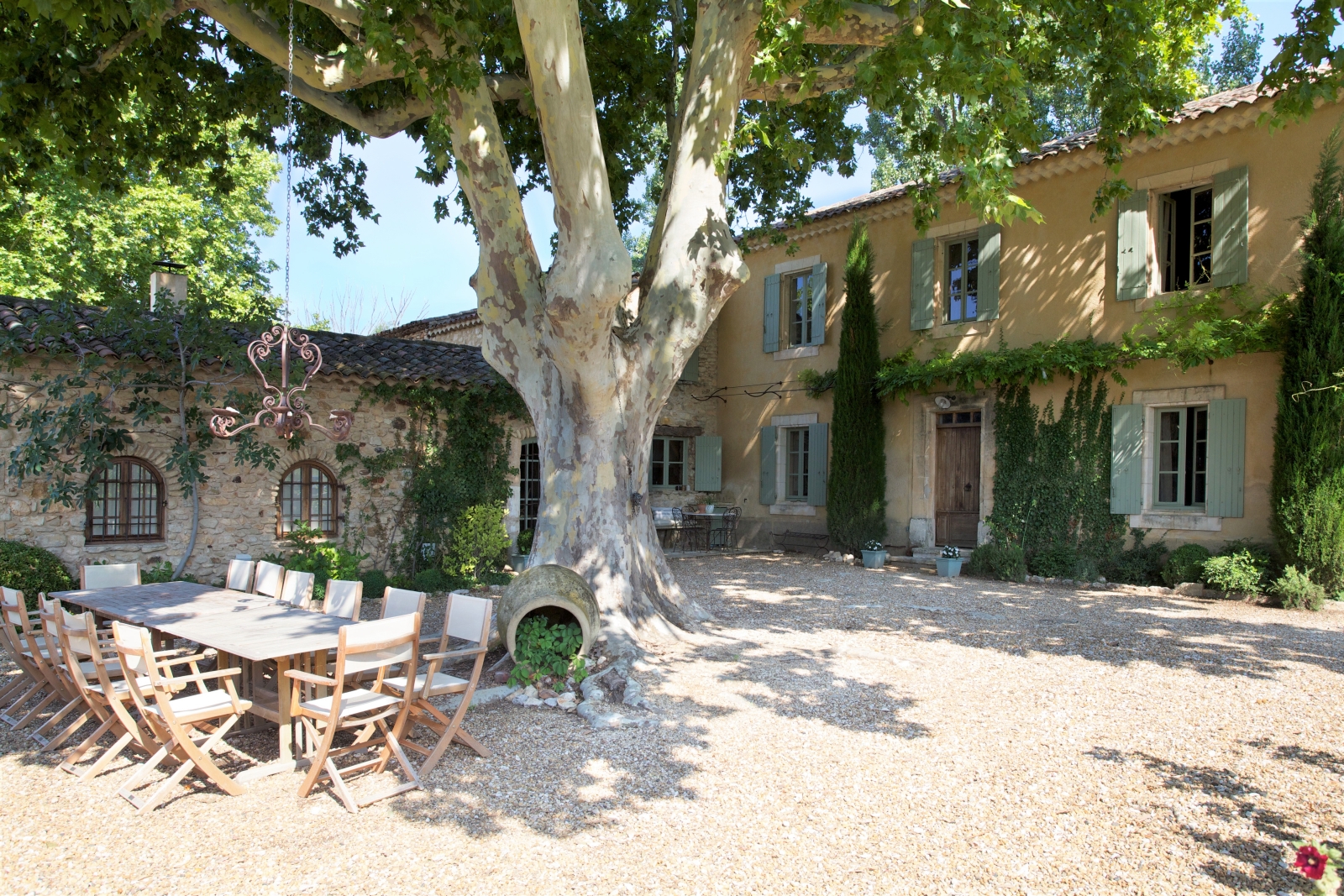 Terrace with long table, chairs and tree at Le Pont Romain in Provence, France