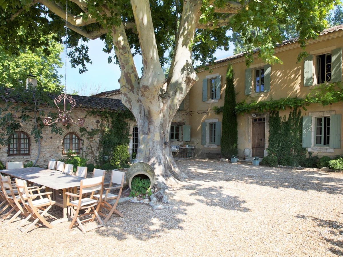 Terrace with long table, chairs and tree at Le Pont Romain in Provence, France