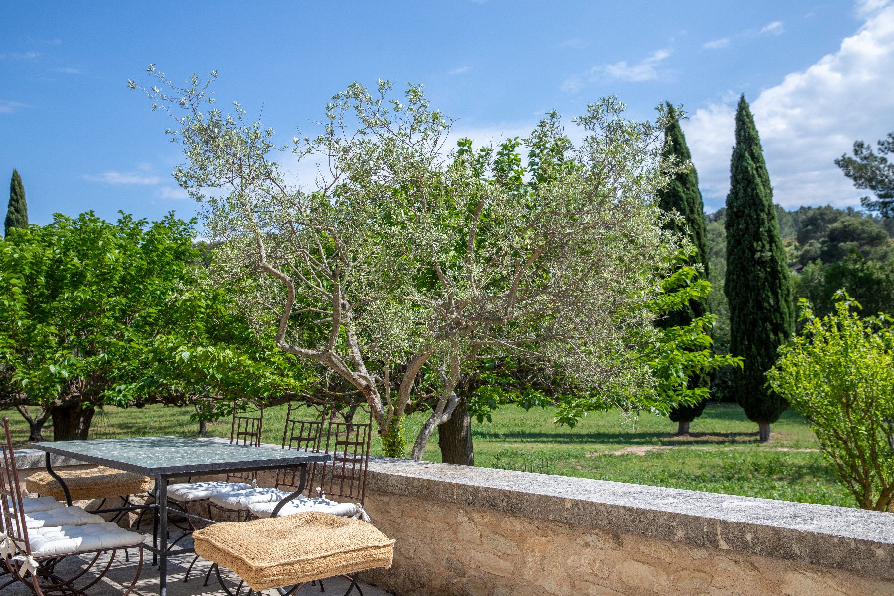 Balcony looking out over gardens and trees at Maison Les Baux, a luxury villa near Les Baux de Provence, France