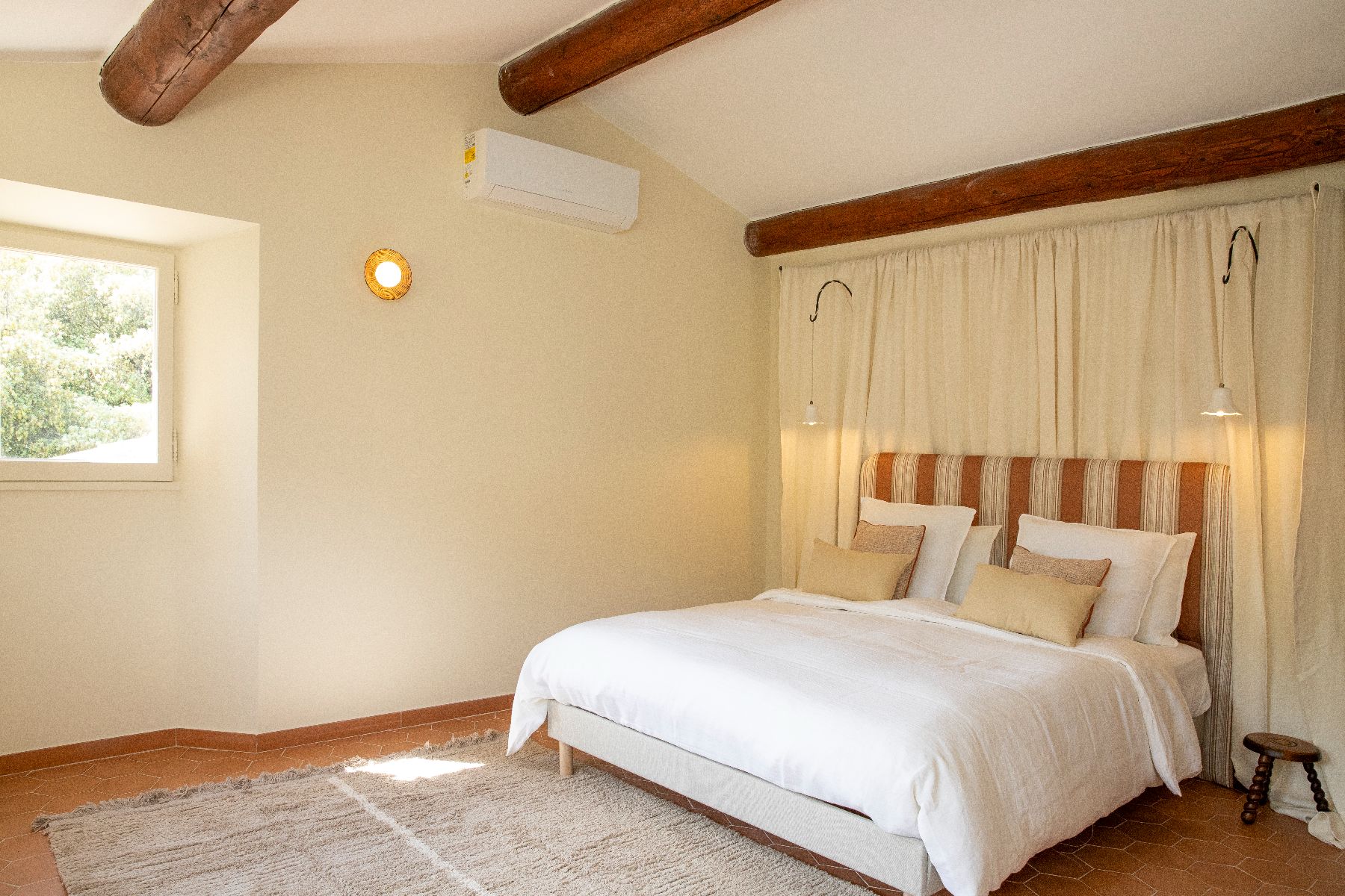 Bedroom in neutral colours, with double bed at Maison Les Baux in Provence, France