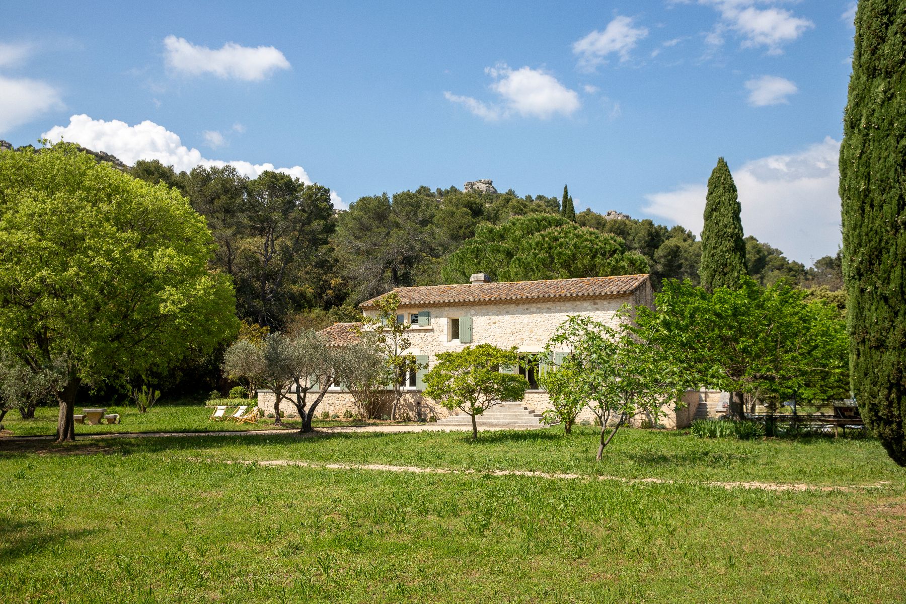 Exterior view of luxury villa, Maison Les Baux in Provence, with gardens and trees in the foreground