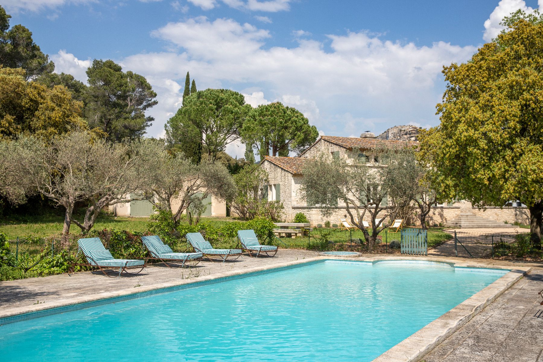 Pool  with sun loungers, and house in the background, at luxury Maison Les Baux near Les Baux de Provence, France