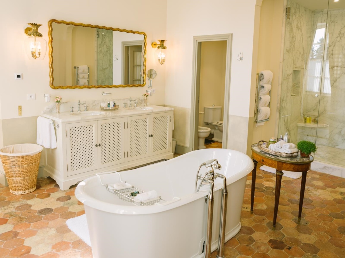 Bathroom with bath, double sinks, large mirror, toilet and shower at Mas de la Motte in Provence, France