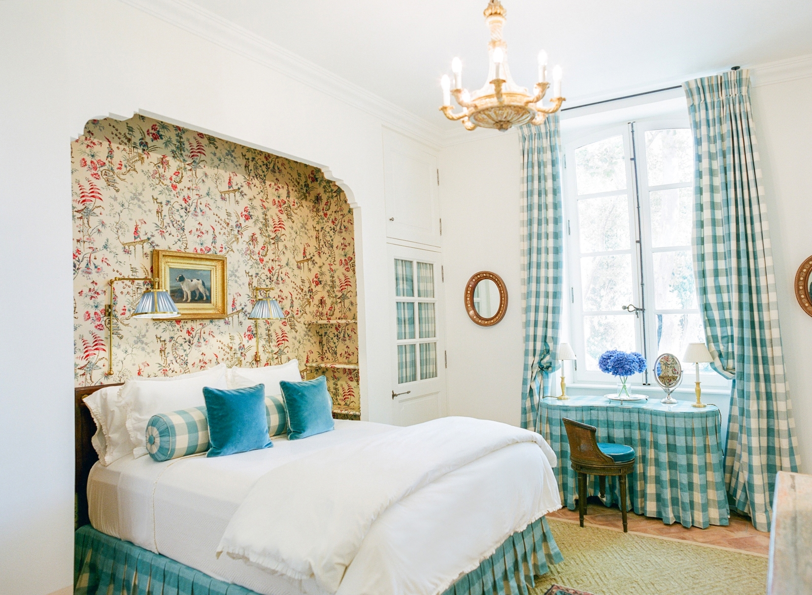 Bedroom with double bed, dressing table, chandelier and Pierre Frey fabric at Mas de la Motte in Provence, France
