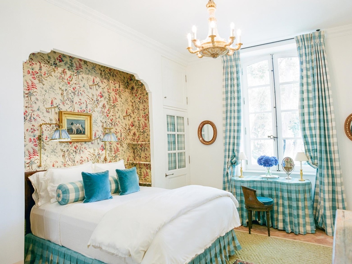 Bedroom with double bed, dressing table, chandelier and Pierre Frey fabric at Mas de la Motte in Provence, France