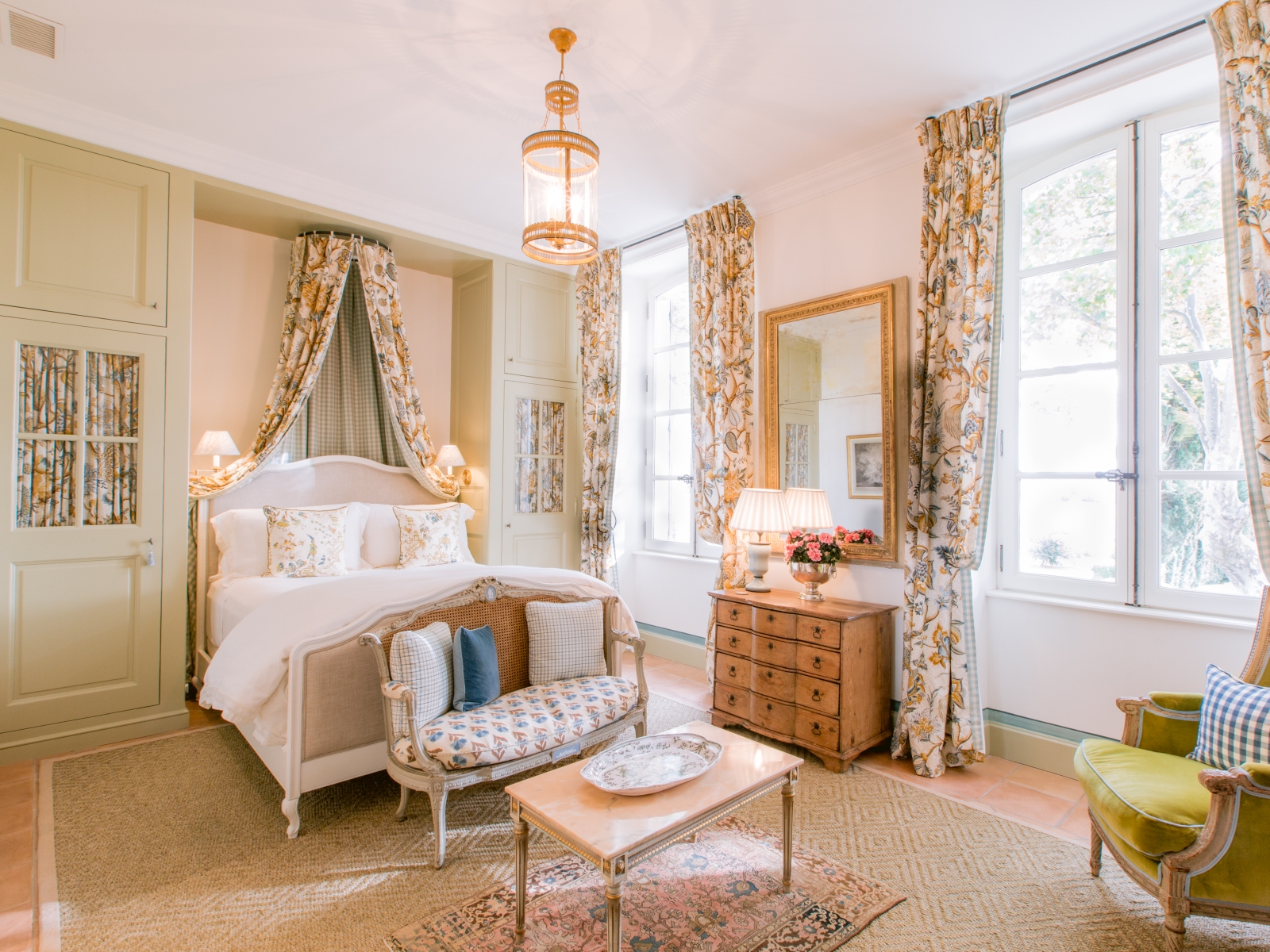 Bedroom with double bed, sofa, table, armchair, cabinet & mirror at Mas de la Motte in Provence, France
