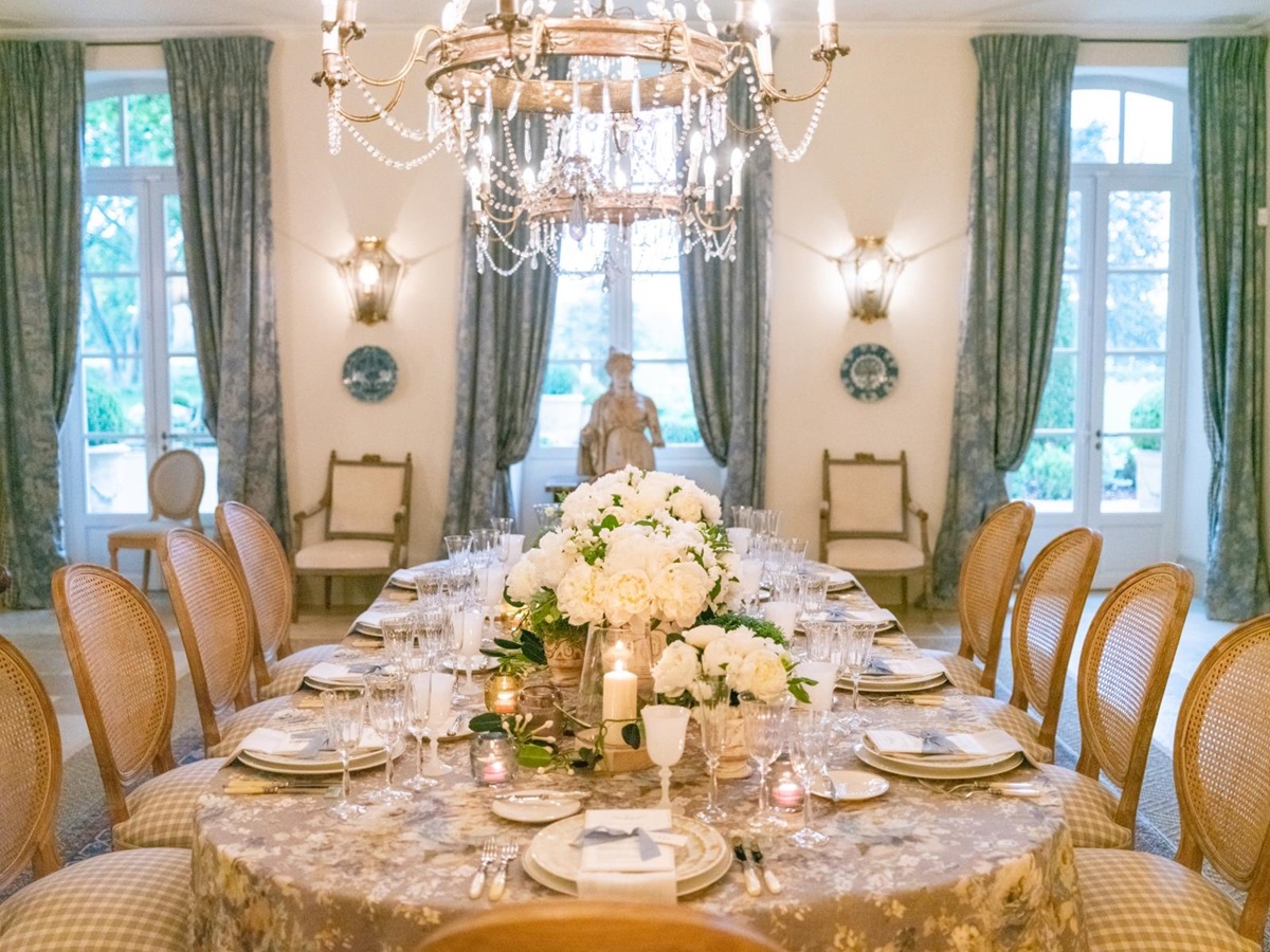 Dining room with dining table, flowers, chandelier, candles and French doors at Mas de la Motte in Provence, France