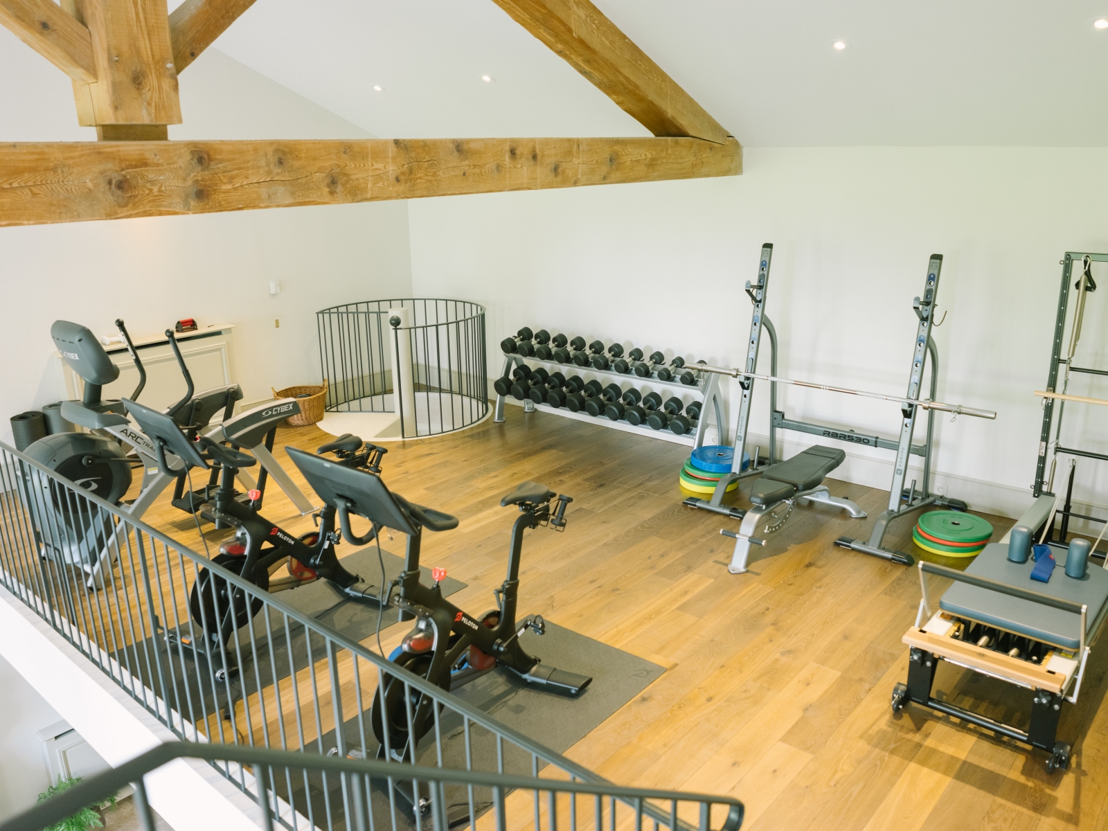 Gym with equipment, ceiling beams and spiral staircase at Mas de la Motte in Provence, France
