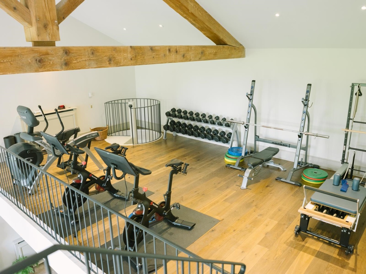 Gym with equipment, ceiling beams and spiral staircase at Mas de la Motte in Provence, France