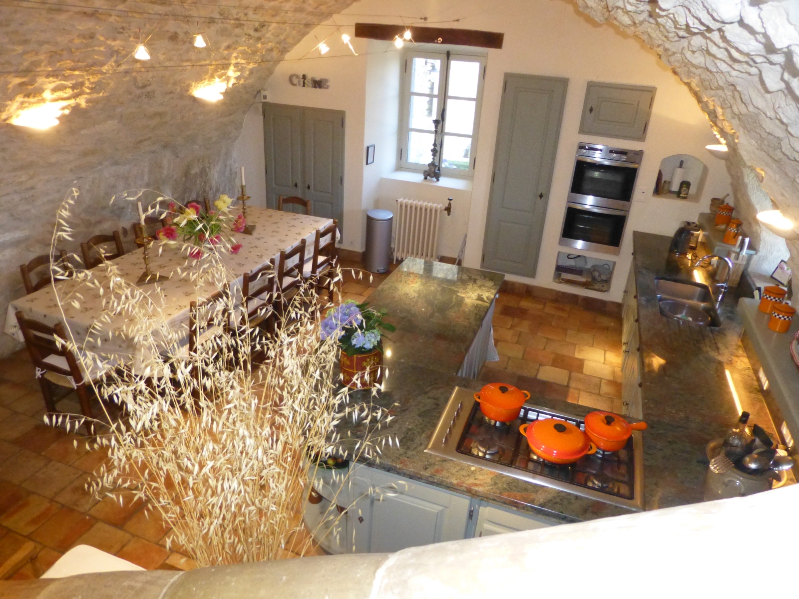 Kitchen with vaulted ceiling, marble worktops, appliances, table, chairs and window at Mas des Cerisiers in Provence, France