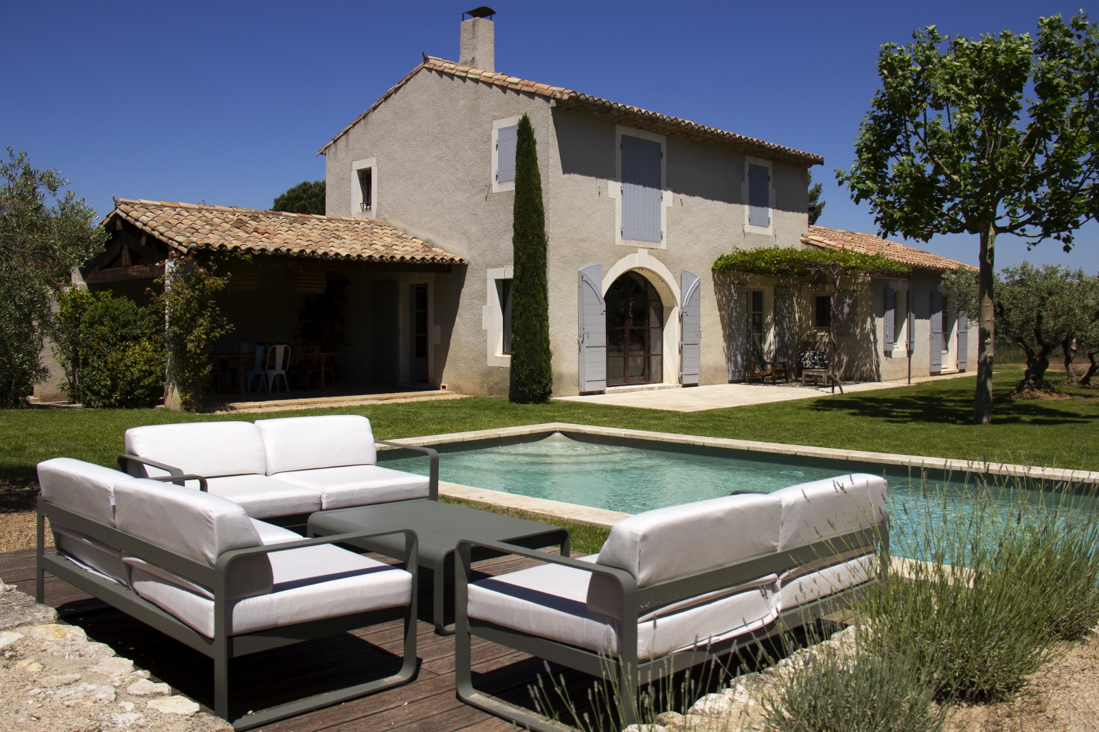 Poolside seating with villa in background at Mas Eygalieres in Provence