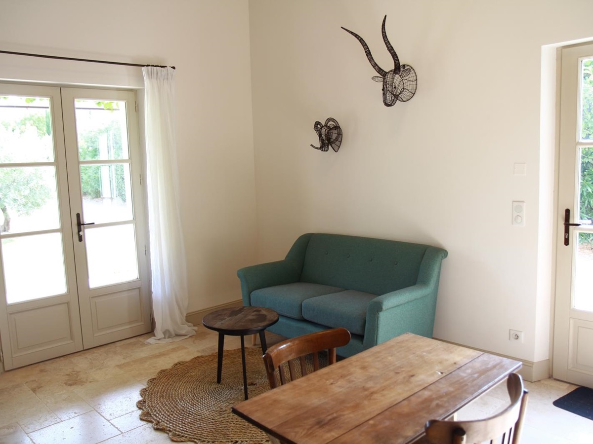 Guest house living area with small table and sofa at Mas Eygalieres in Provence