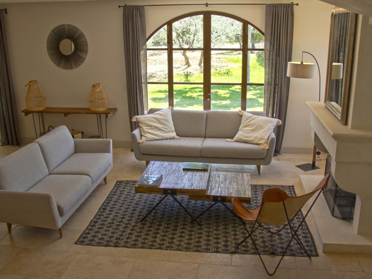 Living room from stairs with white sofas and fireplace at Mas Eygalieres in Provence