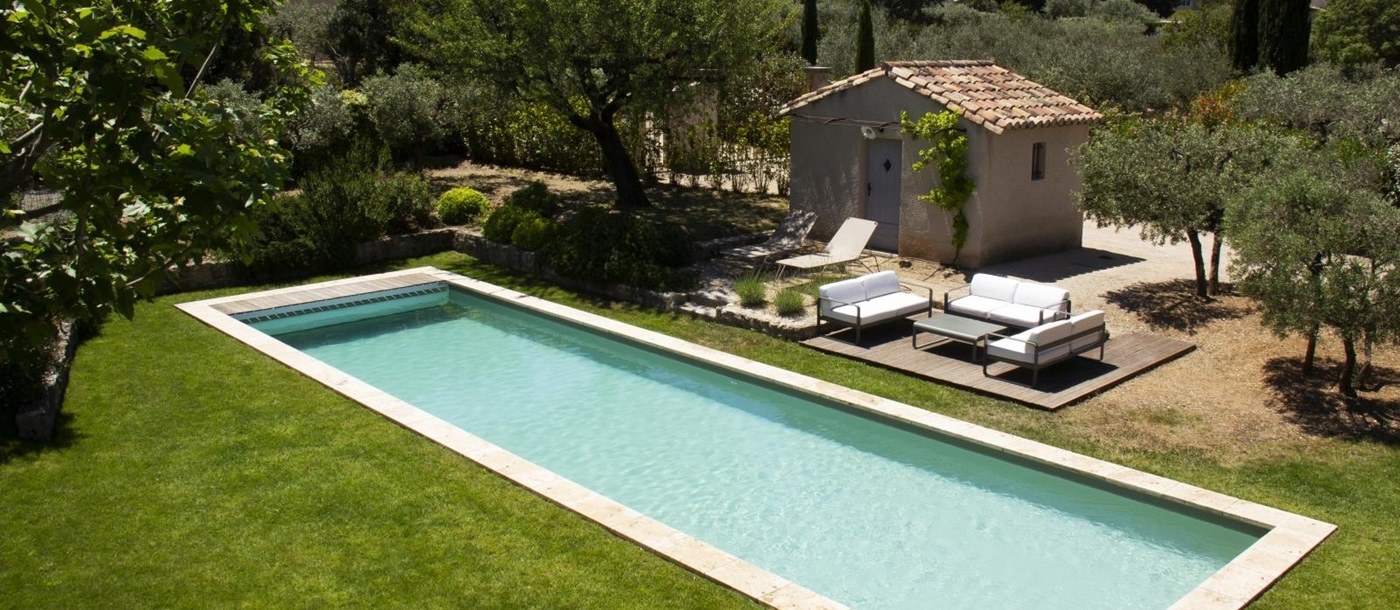 Aerial of pool with pool house and loungers at Mas Eygalieres in Provence