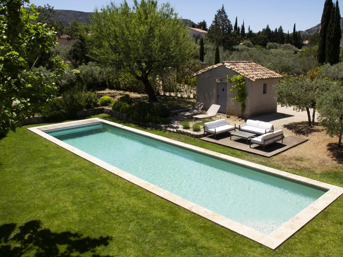 Aerial of pool with pool house and loungers at Mas Eygalieres in Provence