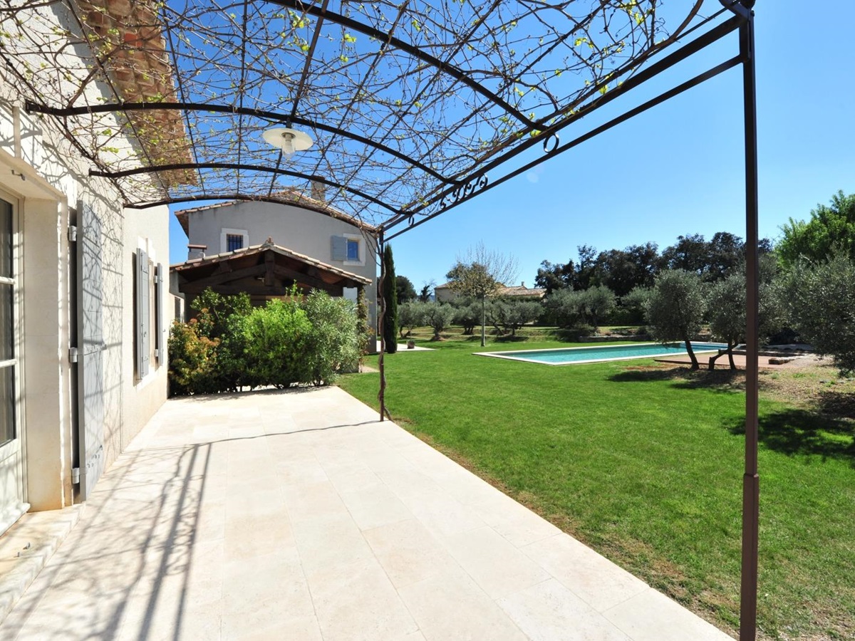 Covered pergola terrace with garden to the right at Mas Eygalieres in Provence