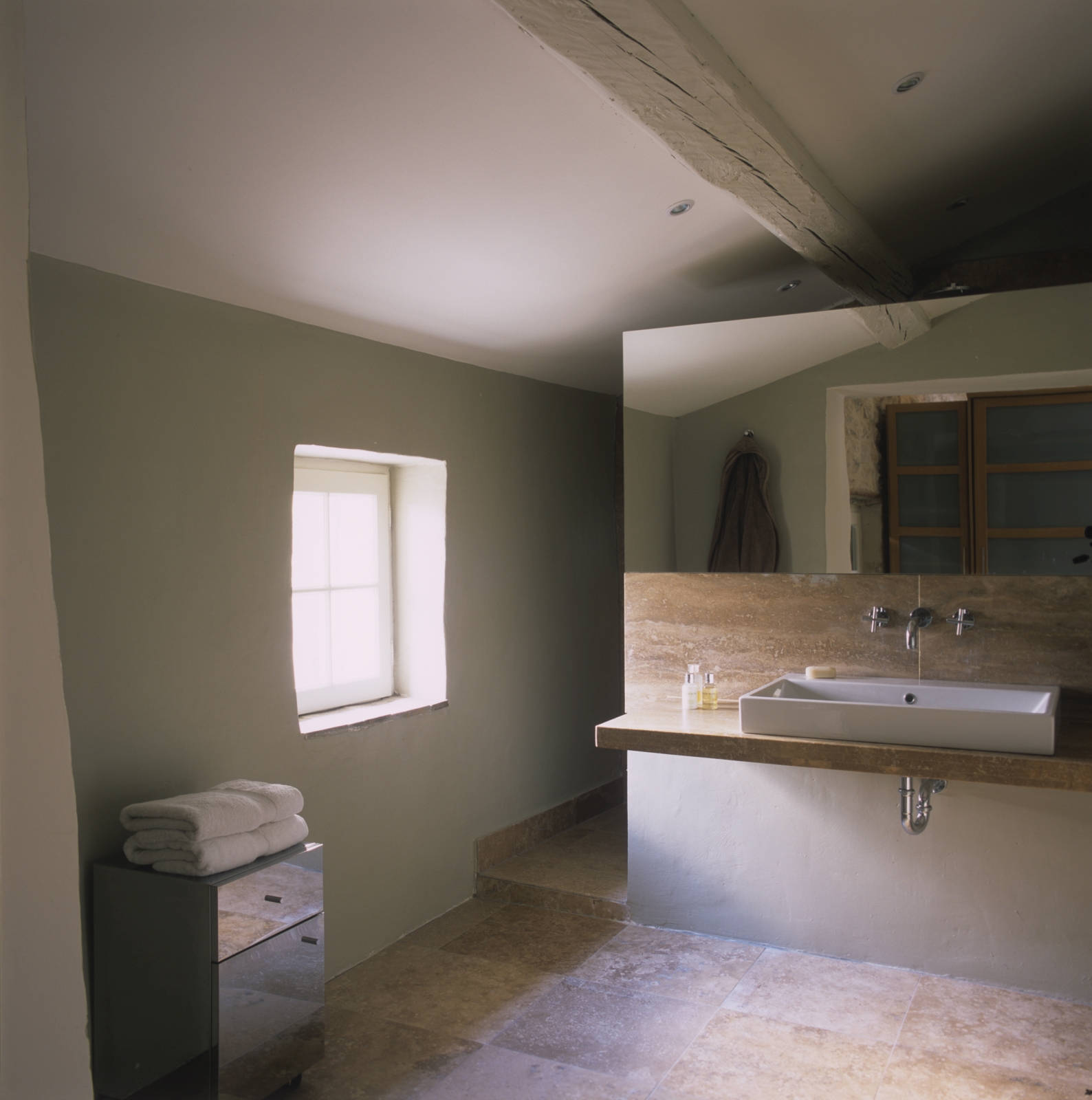 Bathroom with large mirror, sink, cabinet, towels and window at Mas Jaisses in Provence, France