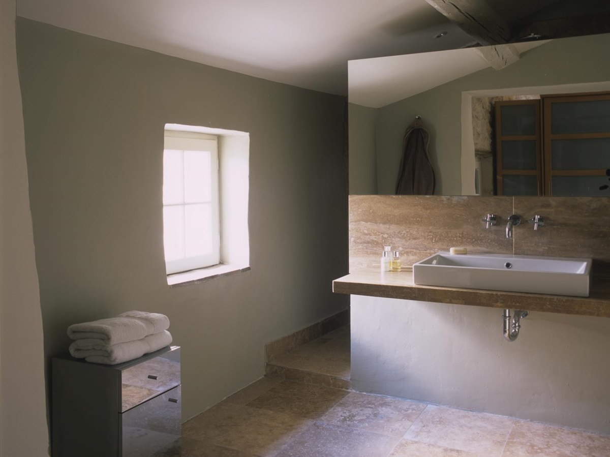 Bathroom with large mirror, sink, cabinet, towels and window at Mas Jaisses in Provence, France