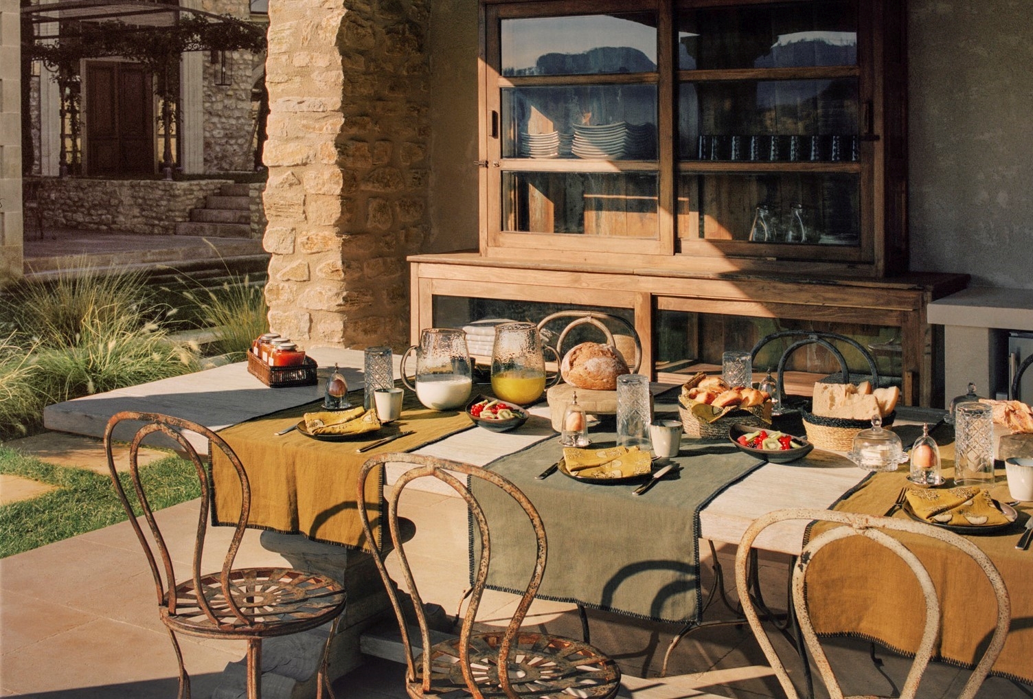 outdoor dining table and chairs on terrace at villa athena in provence, france set for lunch