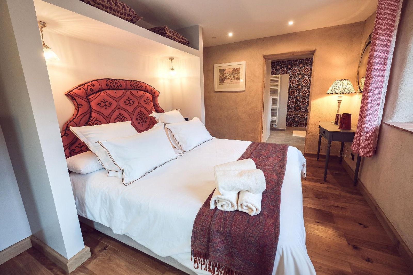 Double bed with red throw at Castelnou in South West France