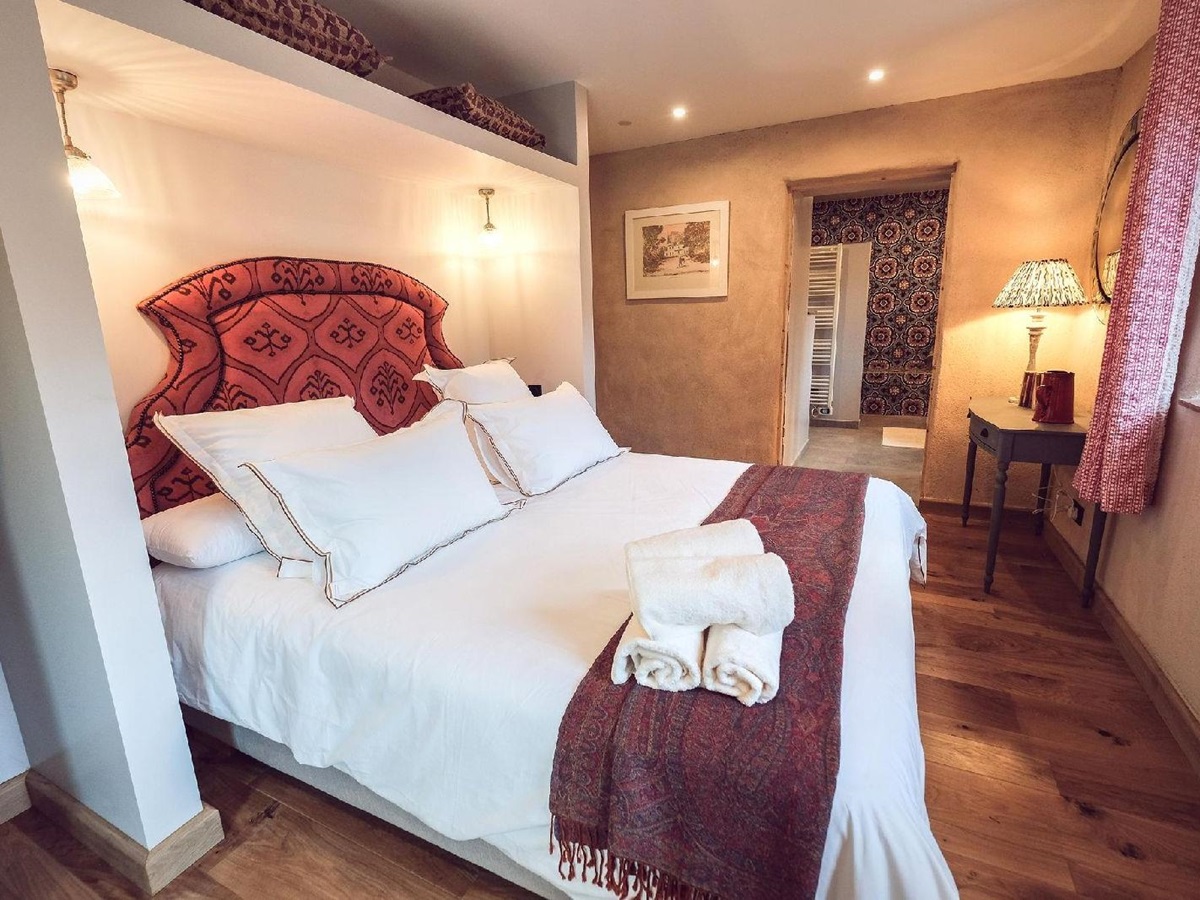 Double bed with red throw at Castelnou in South West France