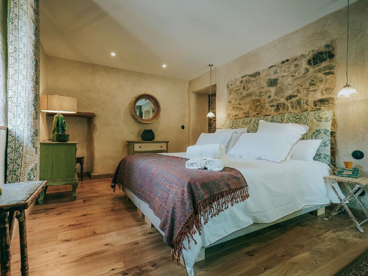 Double bedroom with decorative headboard at Castelnou in South West France