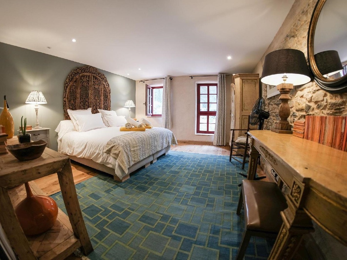 Double bedroom with blue rug at Castelnou in South West France