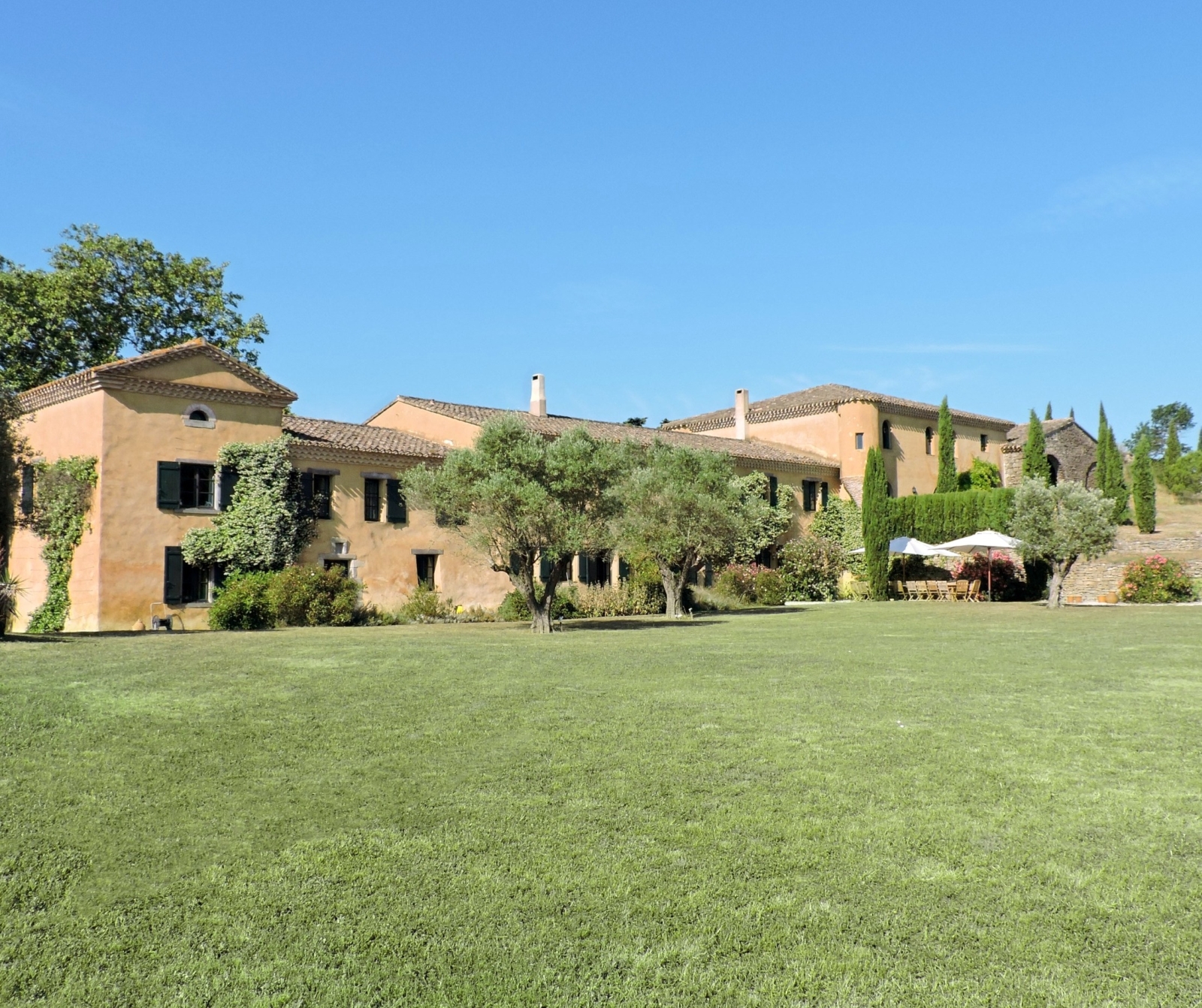 Back of villa and garden with green grass and trees at Domaine de Corbieres in South West France