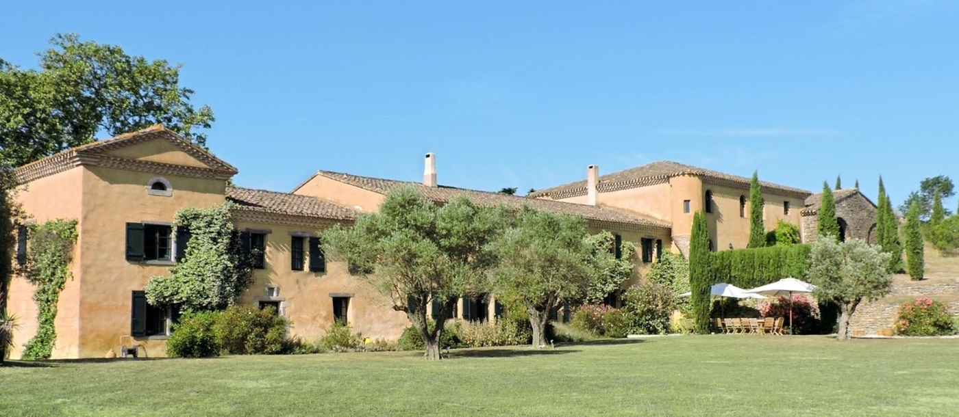 Back of villa and garden with green grass and trees at Domaine de Corbieres in South West France