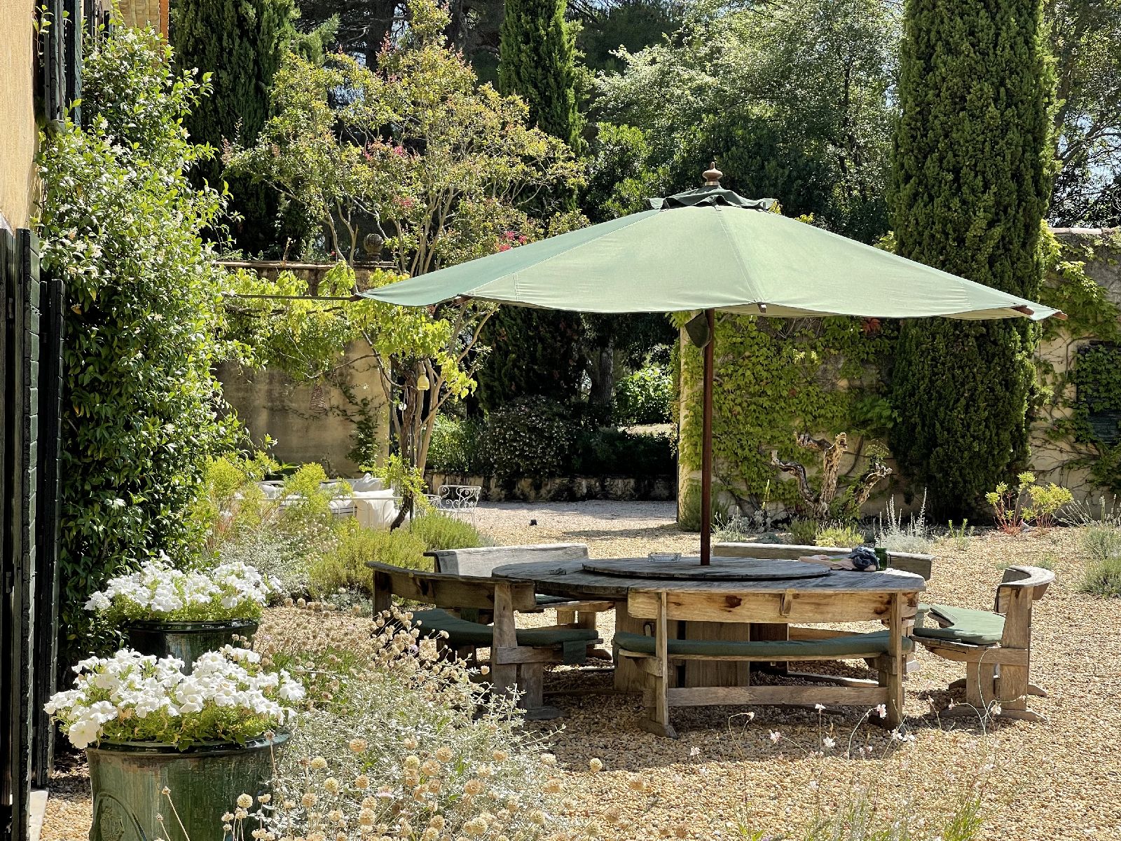 Outdoor shaded dining in the garden at Domaine de la Hille in France